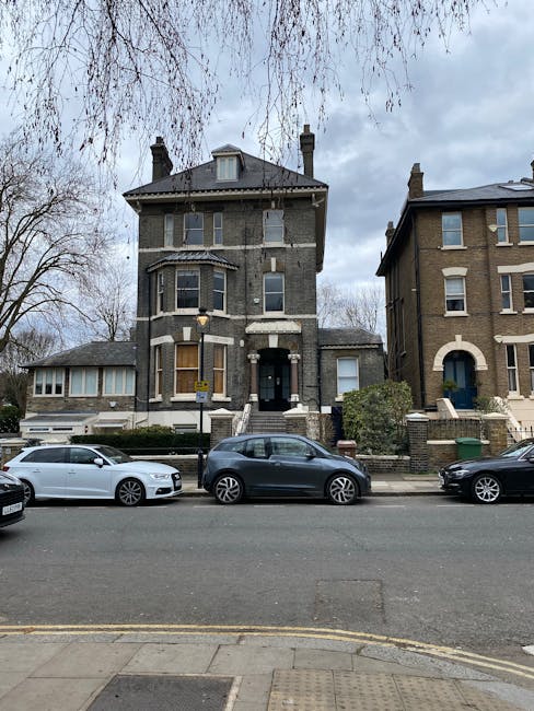 A row of Victorian terraced houses in Harringay with ornate facades painted in pastel shades of light pink, cream, and pale blue, featuring bay windows and decorative molding. The image shows the exte